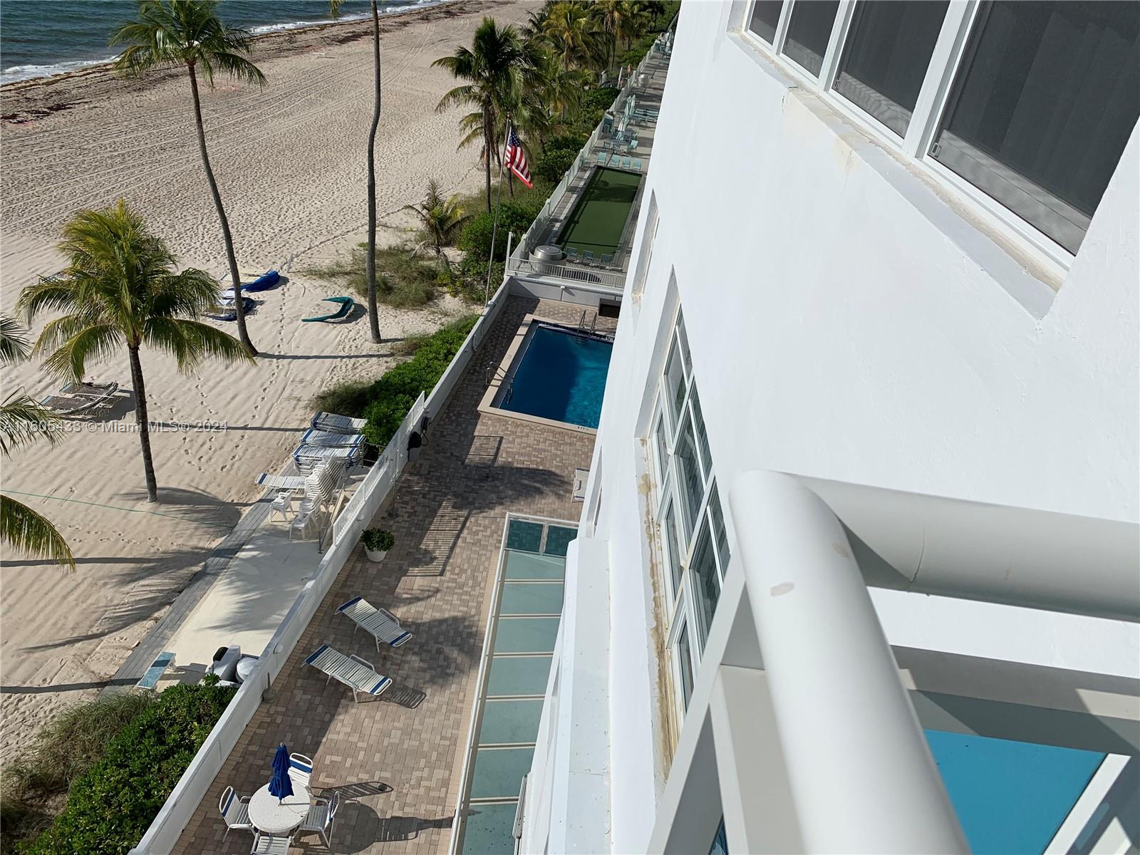 An elevated view shows a beach, a swimming pool, and a patio area next to a building — FORT LAUDERDALE, FL