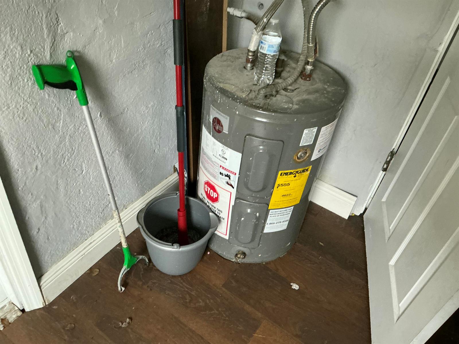 A water heater sits in the corner of a room with wood-look flooring — 5207 Fletcher Street, Hollywood FL 33021, HOLLYWOOD, FL