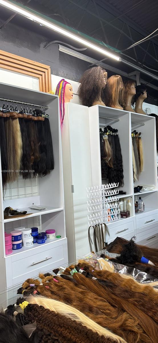 This hair salon features white shelving units displaying various hair extensions and mannequin heads — 1576 NE 205th ter, Miami FL 33179, MIAMI, FL