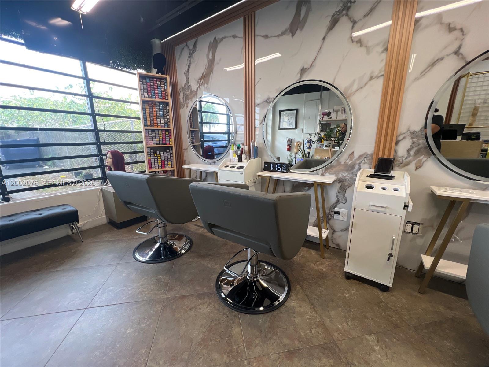 A hair salon features two styling chairs, circular mirrors, and marble-patterned walls — 1576 NE 205th ter, Miami FL 33179, MIAMI, FL