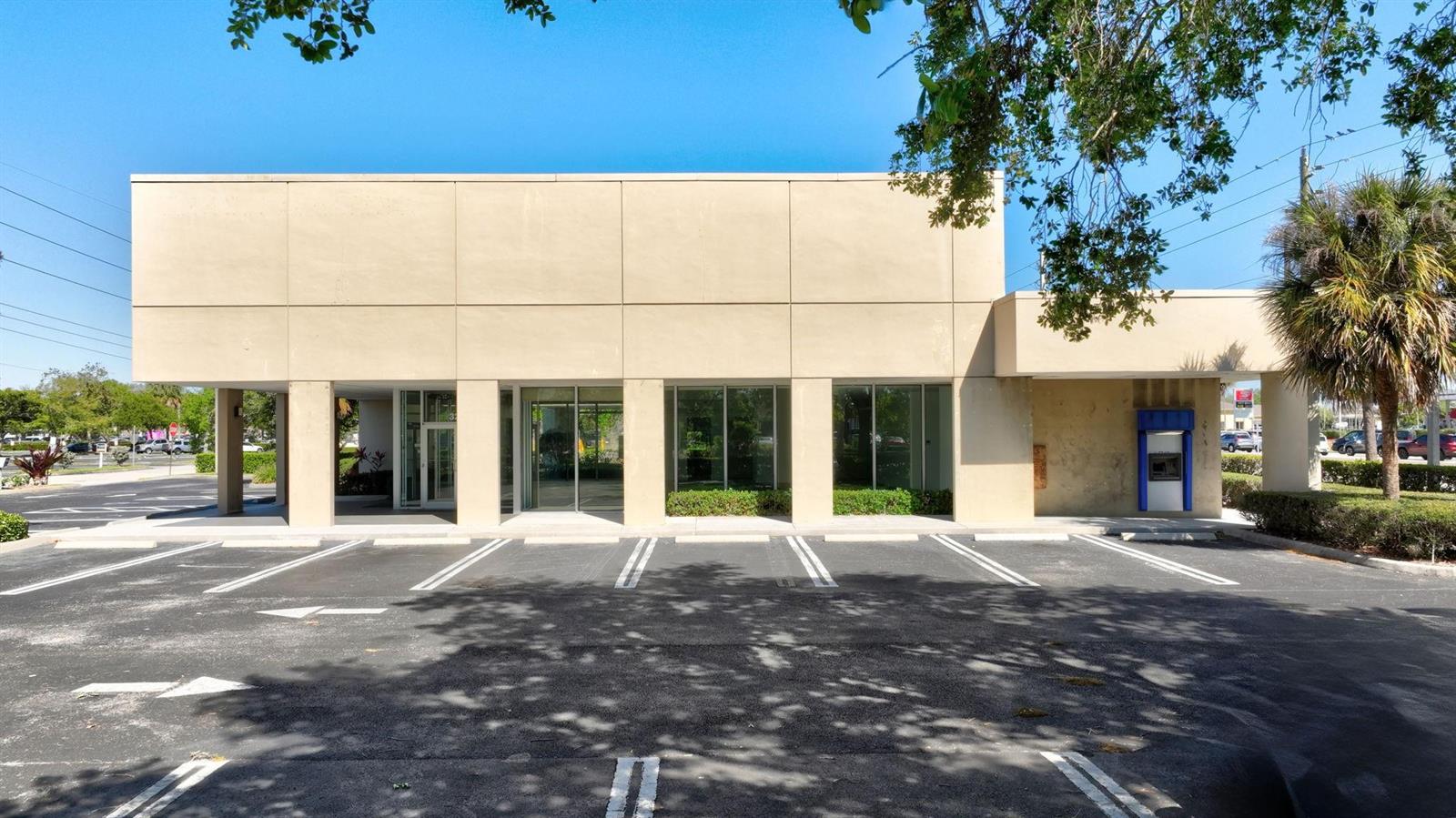 A beige commercial building with large glass windows and an outdoor ATM in a parking lot — 3250 SE Federal Highway, Stuart FL 34997, STUART, FL