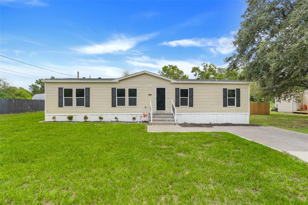A single-story beige manufactured home with black shutters and a concrete driveway — 3417 CARTER ROAD, HAINES CITY, FL