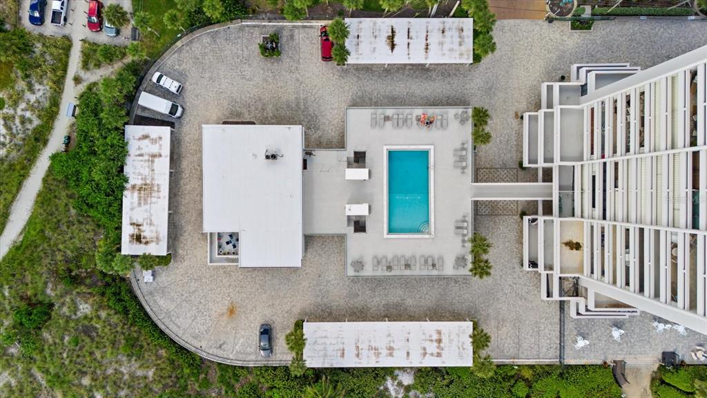 An aerial view shows a building with a swimming pool, parking lot, and covered parking — 5400 OCEAN BOULEVARD UNIT 9-4, SARASOTA, FL