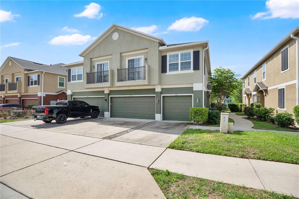 A two-story townhouse exterior features a green garage, balconies, and a concrete driveway — 3031 SAN JACINTO CIRCLE UNIT 3031, SANFORD, FL