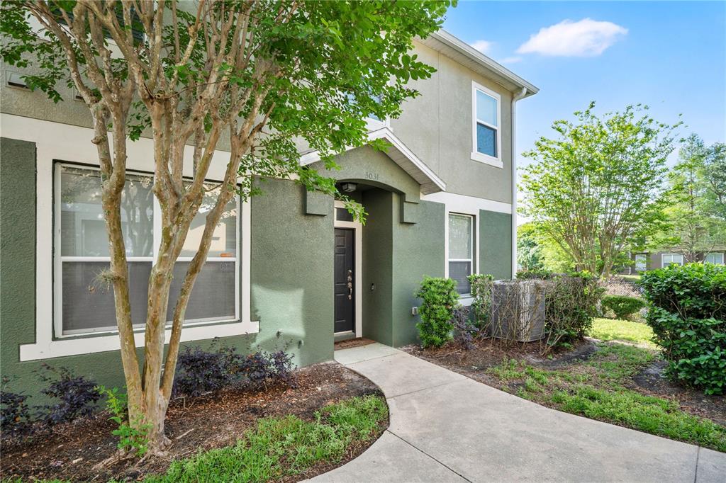 A two-story green stucco building with a concrete walkway leading to the front entrance — 3031 SAN JACINTO CIRCLE UNIT 3031, SANFORD, FL