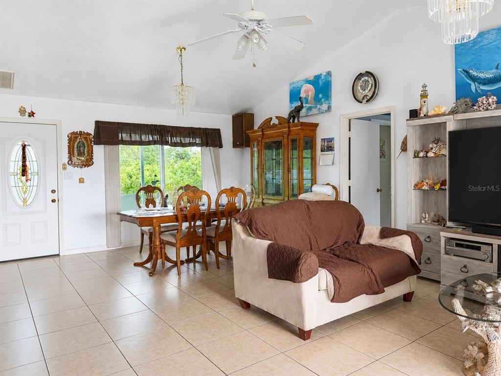 A light blue single-story house with a green lawn and a large tree — 3488 DWIGHT STREET, PORT CHARLOTTE, FL