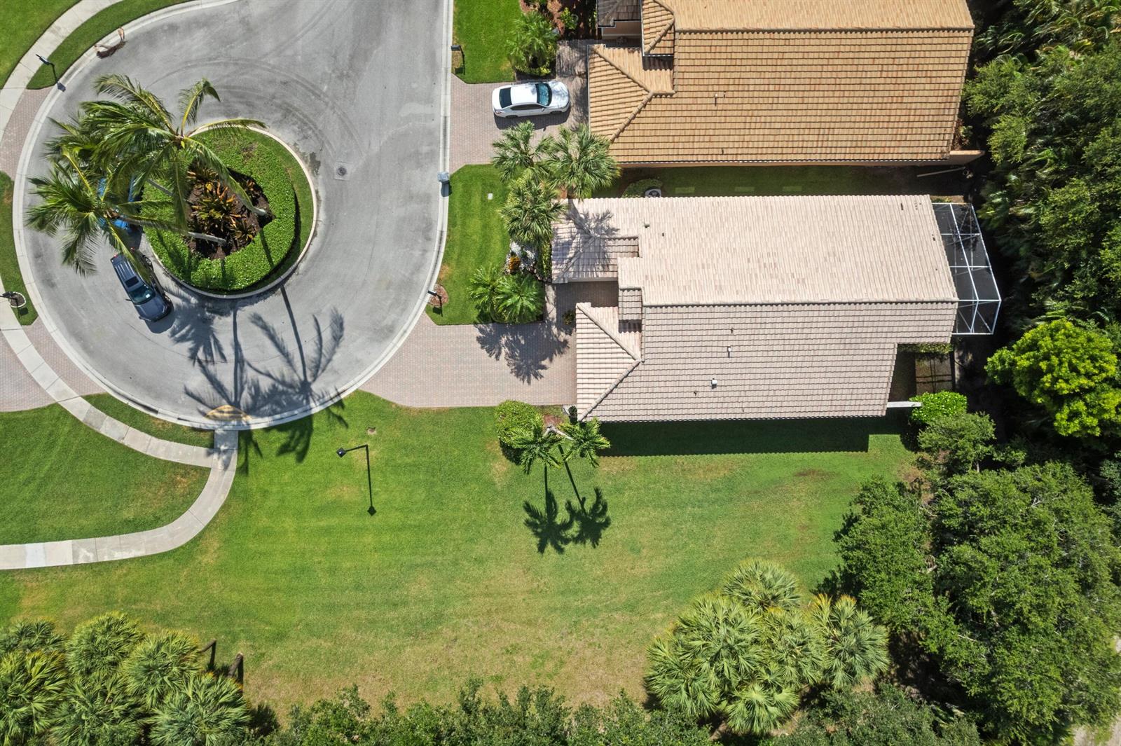 An aerial view shows a house with a tiled roof, a driveway, and surrounding landscaping — 7818 Caprio Drive, Boynton Beach FL 33472, BOYNTON BEACH, FL