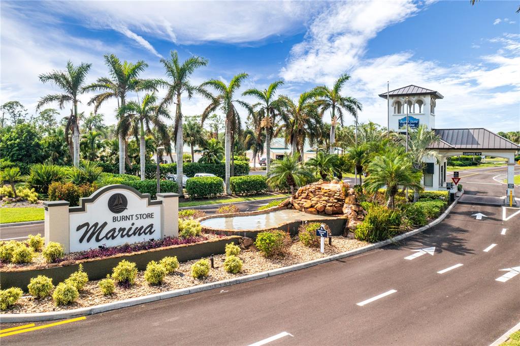 The entrance to Burnt Store Marina features a landscaped sign, a fountain, and palm trees — 2070 KING TARPON DRIVE, PUNTA GORDA, FL