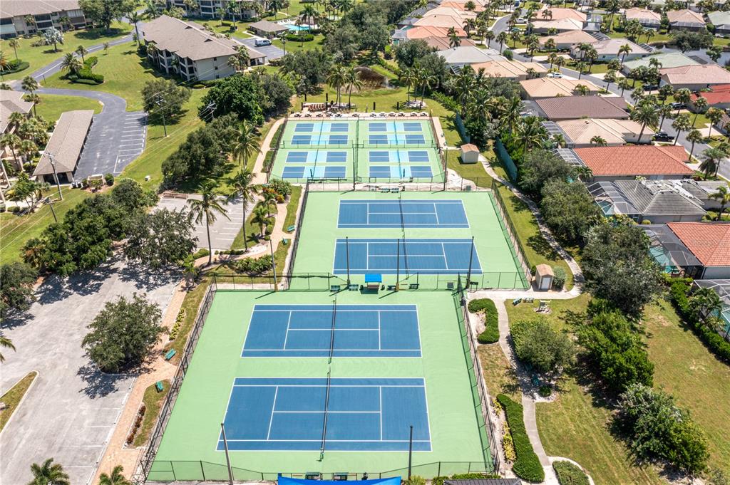 An aerial view shows multiple tennis courts surrounded by trees and residential buildings — 2070 KING TARPON DRIVE, PUNTA GORDA, FL