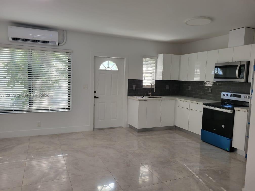 A kitchen with white cabinets, stainless steel appliances, and light tile flooring — 1725 Calais Dr # 6, Miami Beach FL 33141, MIAMI BEACH, FL
