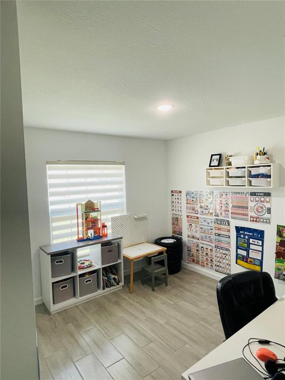A playroom features a white storage unit, a small desk, and educational wall posters — 1409 HILLSBOROUGH WAY, KISSIMMEE, FL