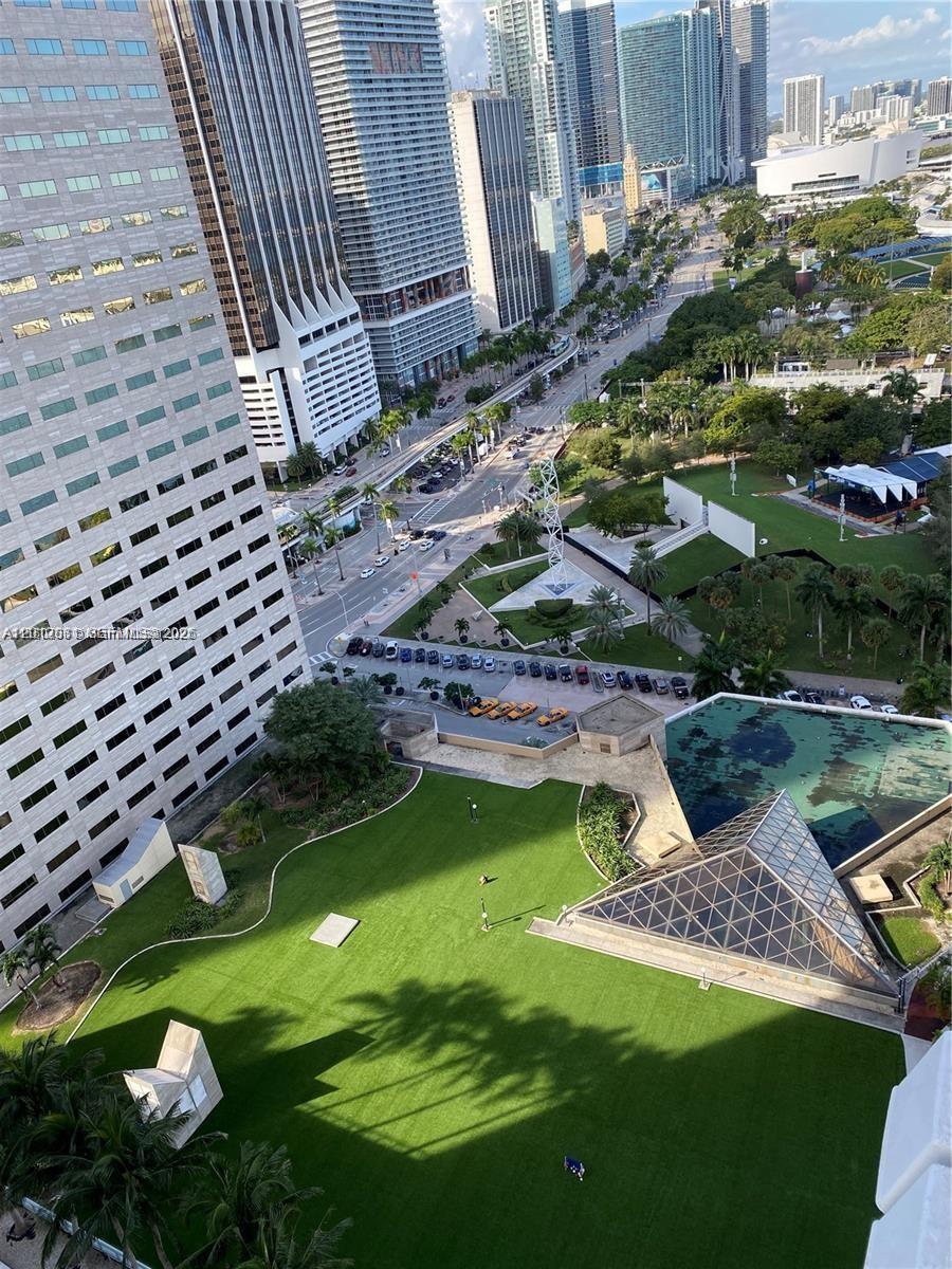 An elevated view of a green rooftop terrace overlooking a city street and skyscrapers — 335 S Biscayne Blvd # 2900, Miami FL 33131, MIAMI, FL