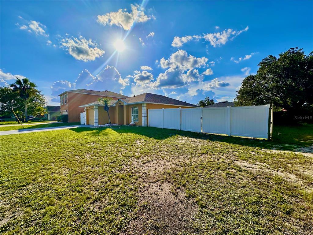 A single-story house with a white vinyl fence and a large grassy yard — 750 PELICAN COURT, KISSIMMEE, FL