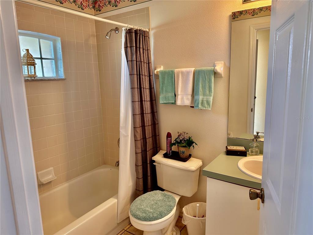 A bathroom features a tiled shower-tub combination, a toilet with a cover, and a vanity — 750 PELICAN COURT, KISSIMMEE, FL