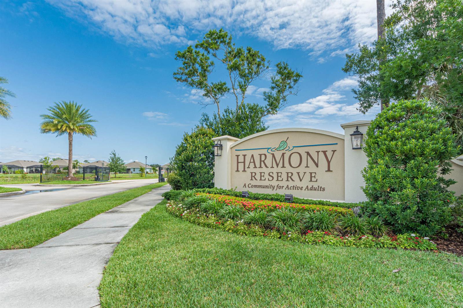 A sign for Harmony Reserve stands beside a sidewalk leading to a gated community entrance — 3409 Wild Banyan Way, Vero Beach FL 32966, VERO BEACH, FL