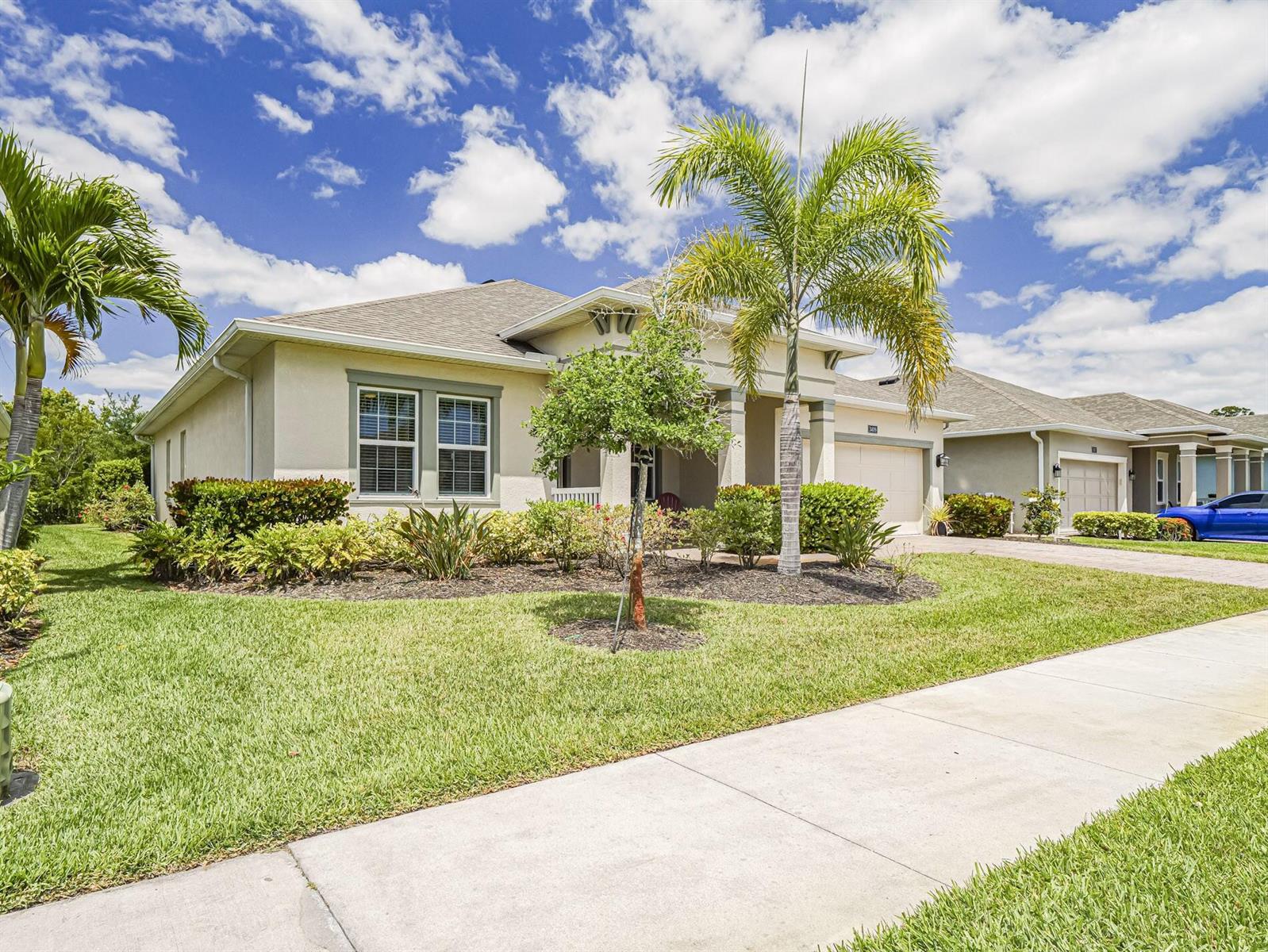 A single-story suburban house with a palm tree, manicured landscaping, and a concrete driveway — 3409 Wild Banyan Way, Vero Beach FL 32966, VERO BEACH, FL
