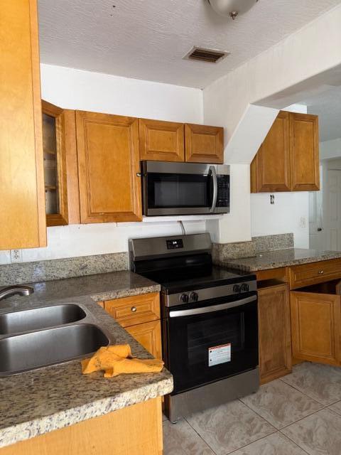A kitchen features wood cabinets, granite countertops, a stainless steel stove, and a microwave — 2975 NW 96th Street, Miami FL 33147, MIAMI, FL