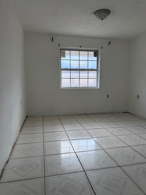 An empty room with white walls, a single window, and light-colored square floor tiles — 2975 NW 96th Street, Miami FL 33147, MIAMI, FL