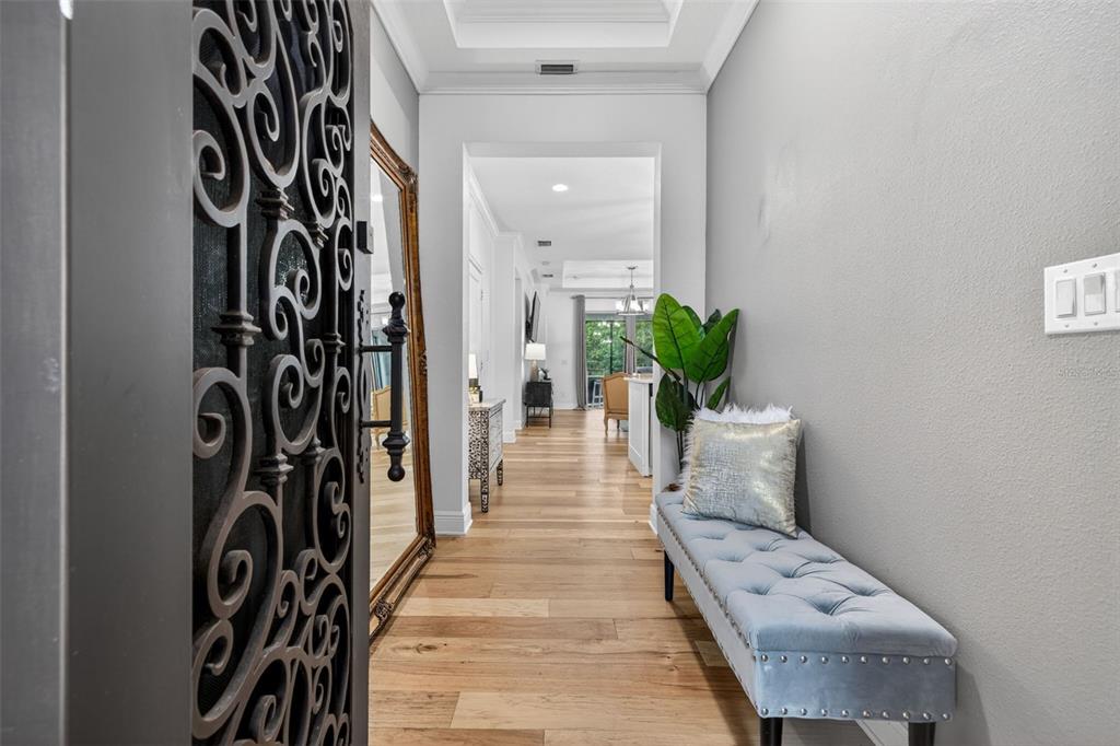 A foyer features a decorative metal door, a tufted bench, and a large floor mirror — 19333 FORT KING RUN, BROOKSVILLE, FL