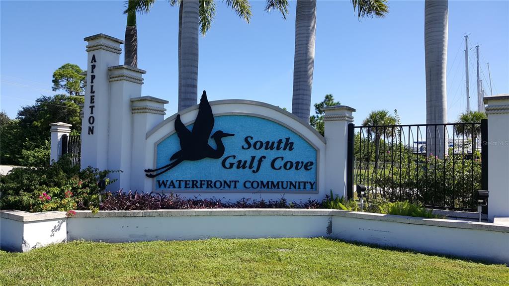 A white monument sign for South Gulf Cove Waterfront Community stands in a grassy area — 10022 CALUMET BOULEVARD, PORT CHARLOTTE, FL