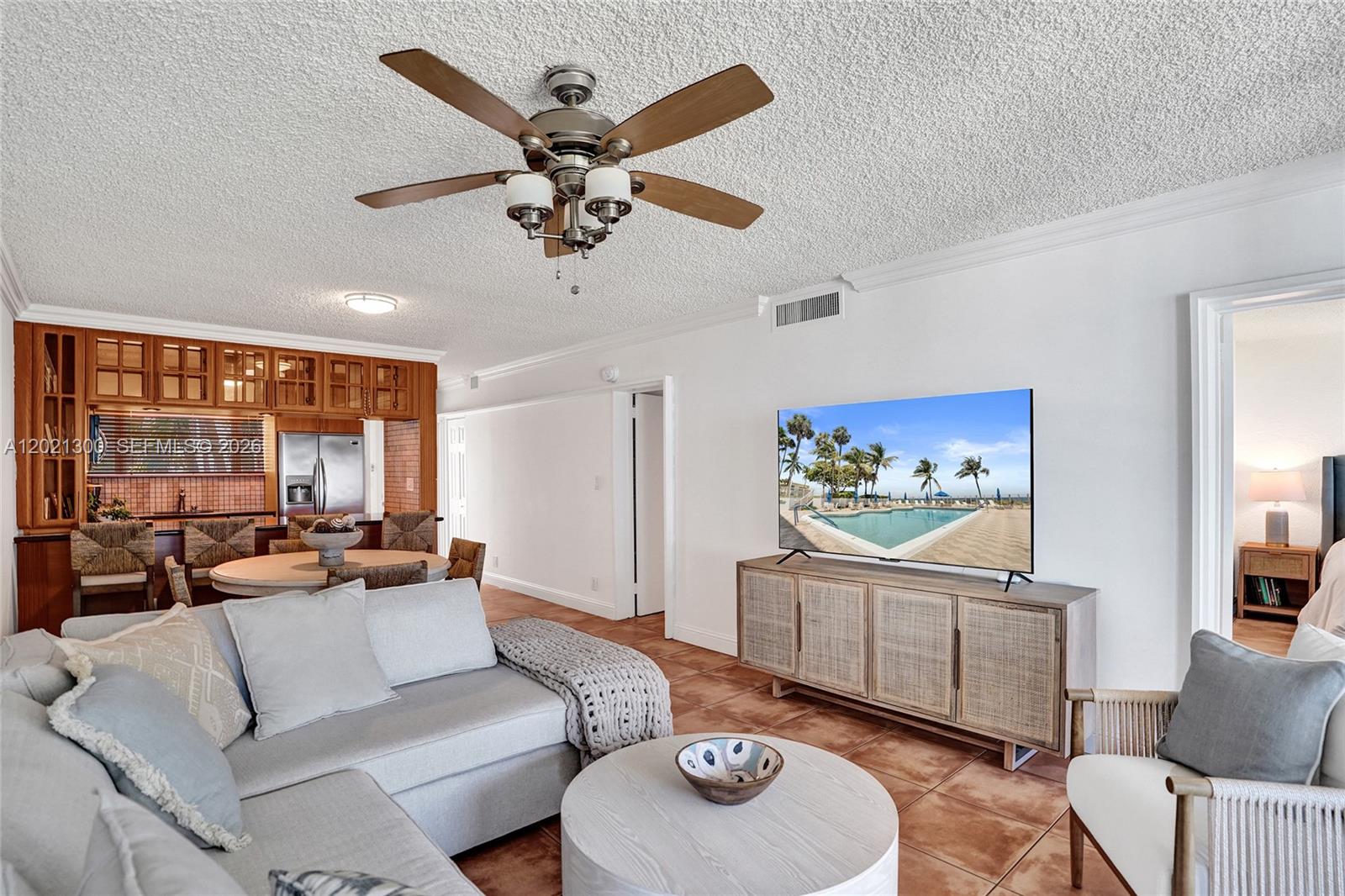 A living room features a sectional sofa, a television on a cabinet, and a ceiling fan — 500 SE 21st Ave # 211, Deerfield Beach FL 33441, DEERFIELD BEACH, FL