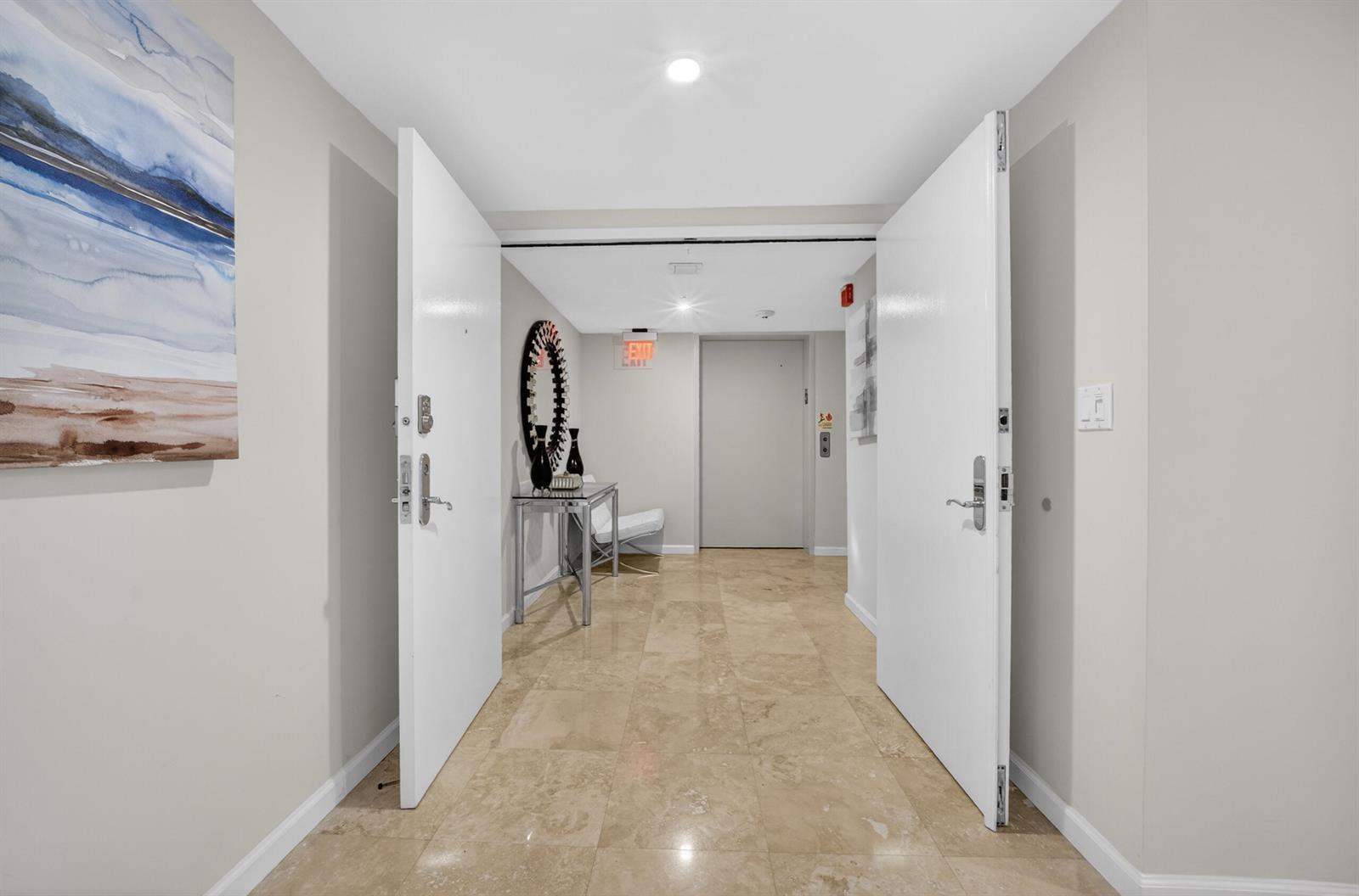 A wide entryway features double white doors, beige tile flooring, and a console table — 45 Hendricks Isle # 403, Fort Lauderdale FL 33301, FORT LAUDERDALE, FL