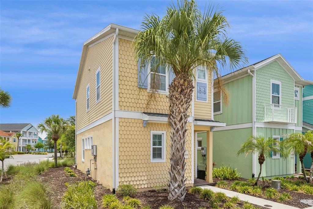 A yellow two-story house with a palm tree in the front yard — 8065 LOST SHAKER LANE, KISSIMMEE, FL