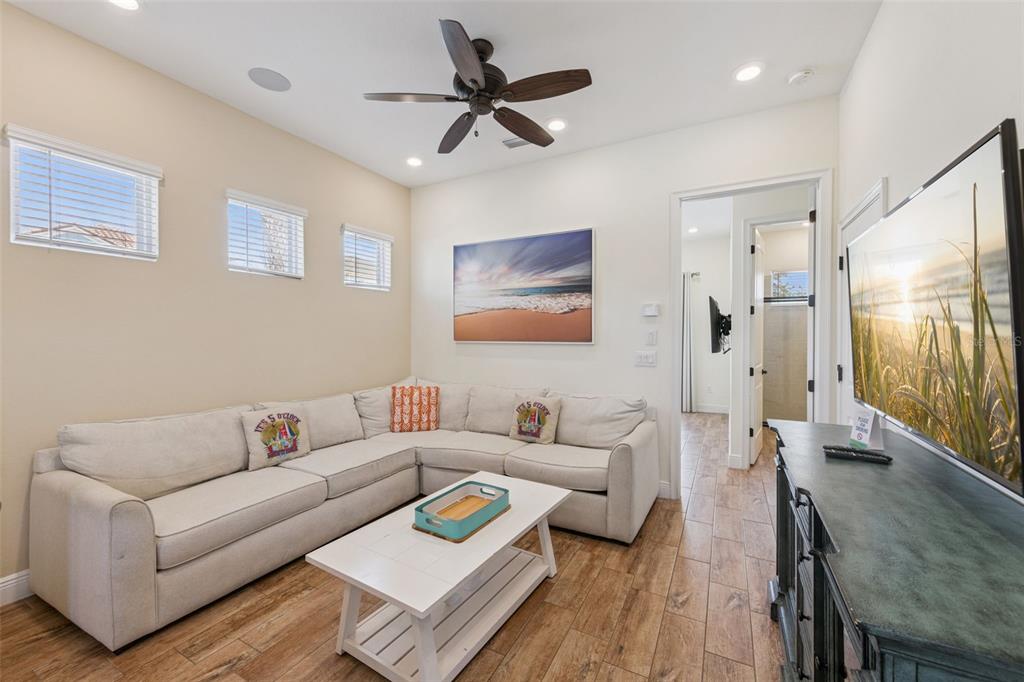 A living room features a beige sectional sofa, a white coffee table, and wood-look flooring — 8065 LOST SHAKER LANE, KISSIMMEE, FL