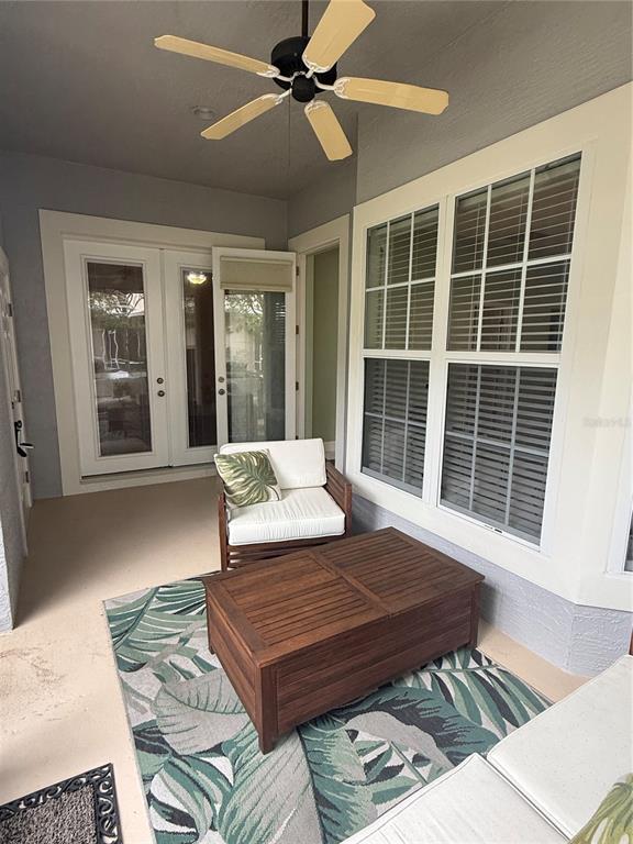A covered patio features a ceiling fan, a wooden coffee table, and a patterned rug — 3132 CONNEMARA DRIVE, ORMOND BEACH, FL