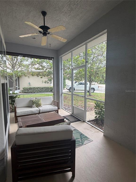 A screened-in porch features a ceiling fan, outdoor furniture, and views of a parked truck — 3132 CONNEMARA DRIVE, ORMOND BEACH, FL