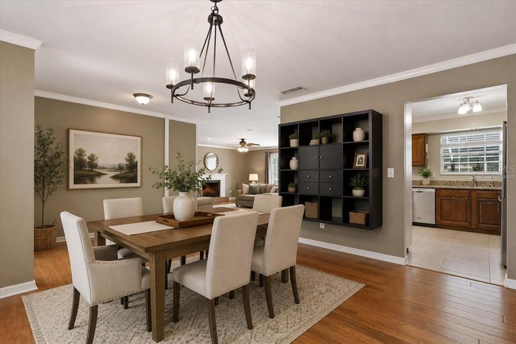 A dining room with a wooden table, upholstered chairs, a chandelier, and an open kitchen — 5515 SW 35TH WAY, GAINESVILLE, FL