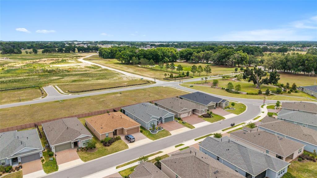 An aerial view shows a suburban neighborhood with single-family homes and a nearby undeveloped field — 4355 NW 53RD COURT, OCALA, FL
