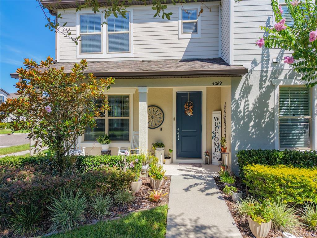 A two-story house exterior features a blue front door, a walkway, and landscaped front yard — 5069 CASPIAN STREET, ST CLOUD, FL