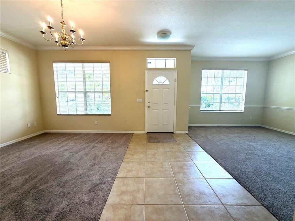 An entryway with tile flooring leads to two carpeted living areas with large windows — 14205 BRIDGEWATER CROSSINGS BOULEVARD, WINDERMERE, FL