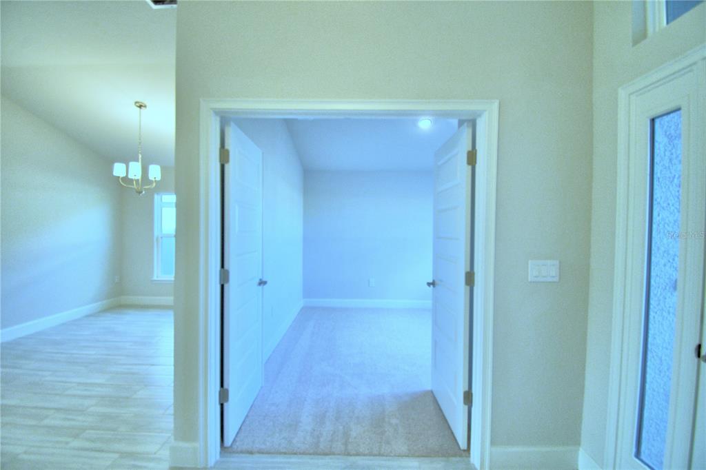 A dark gray front door is set within a light gray stucco entryway with a lantern — 1249 TAGLIAMENTO LANE, HAINES CITY, FL
