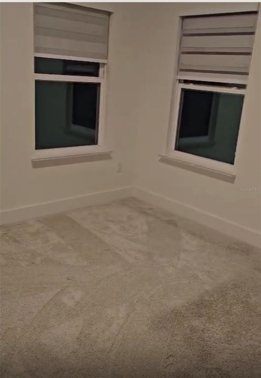 An empty bedroom features white walls, light-colored carpet, and two windows with striped roller shades — 14978 LEBEAU LOOP, WINTER GARDEN, FL