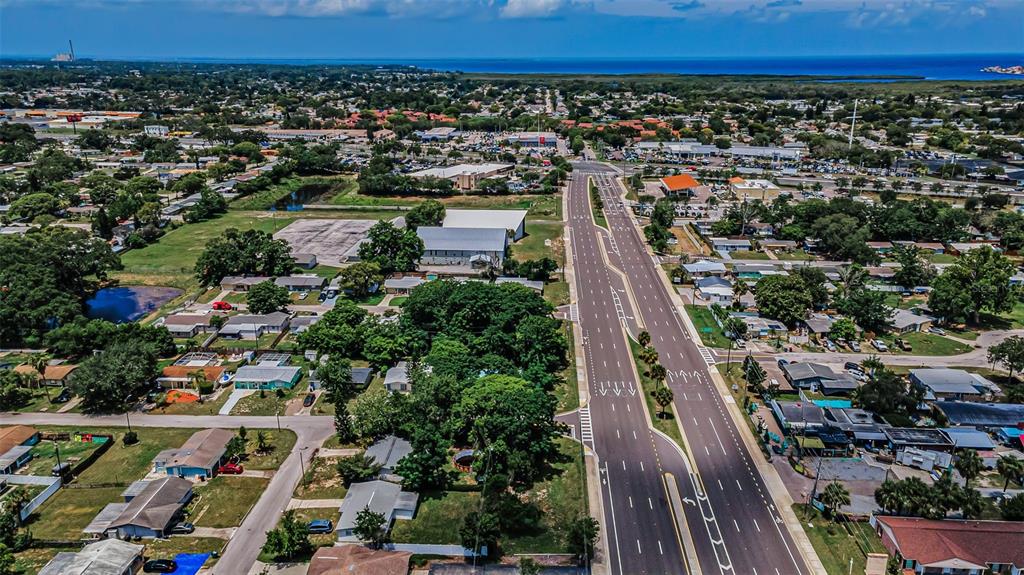 An aerial view shows a multi-lane road running through a suburban neighborhood near the coast — SR 54, NEW PORT RICHEY, FL