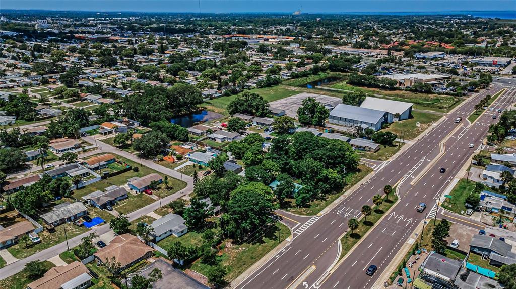 An aerial view shows a residential neighborhood adjacent to a multi-lane divided highway — SR 54, NEW PORT RICHEY, FL