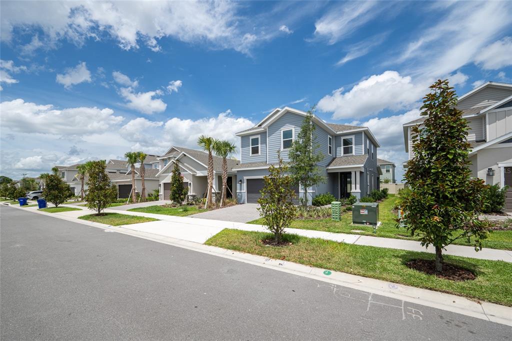 A two-story blue house with a two-car garage sits on a suburban street — 1029 LADYFISH TRAIL, ST CLOUD, FL