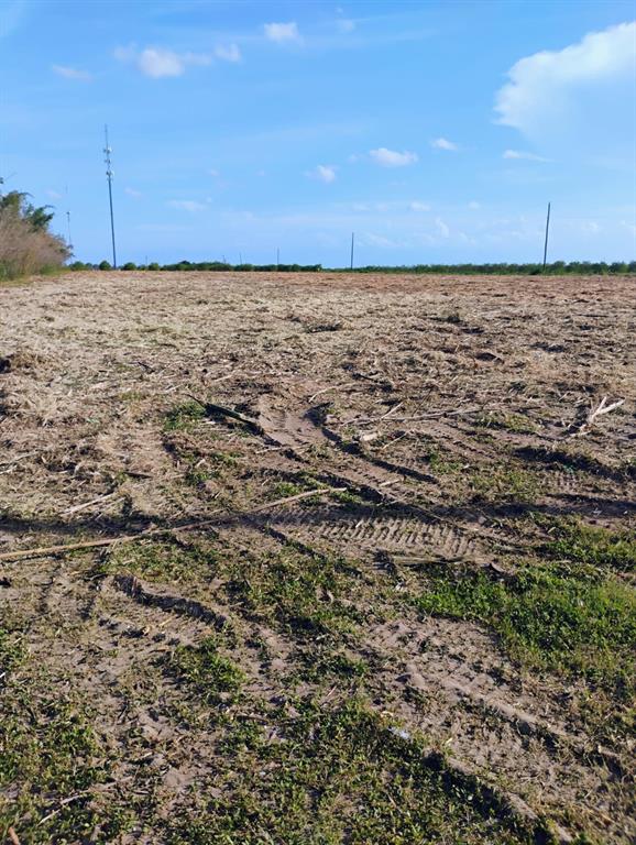 A large, flat, cleared field of dirt and sparse vegetation under a blue sky — 5933 MIKE KAHN ROAD, SEBRING, FL