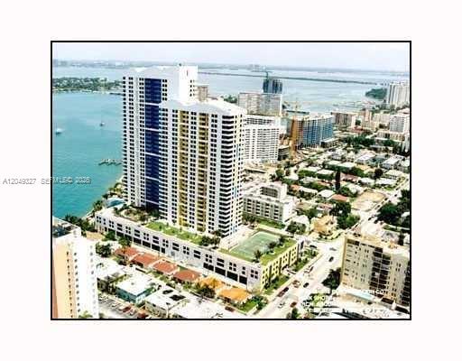 An aerial view shows a tall residential high-rise building situated next to a body of water — 1330 West Ave # 2212, Miami Beach FL 33139, MIAMI BEACH, FL
