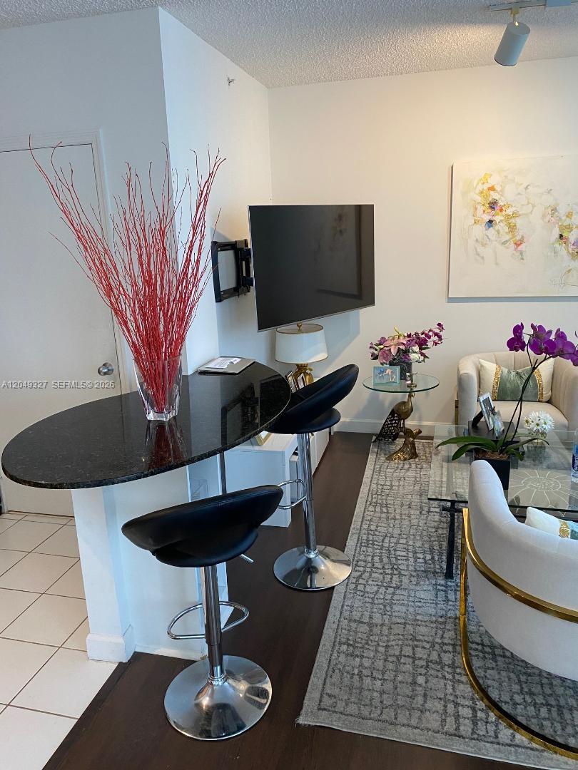 A living area features a black granite breakfast bar, two stools, and a wall-mounted television — 1330 West Ave # 2212, Miami Beach FL 33139, MIAMI BEACH, FL
