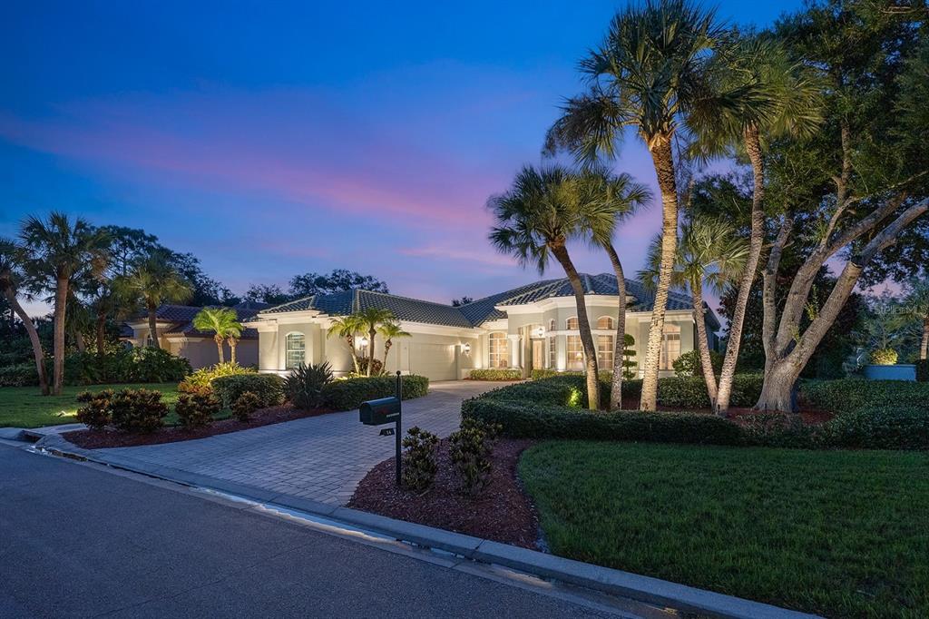 A single-story house with a paved driveway and palm trees at dusk — 24 GRAND PALMS BOULEVARD, ENGLEWOOD, FL