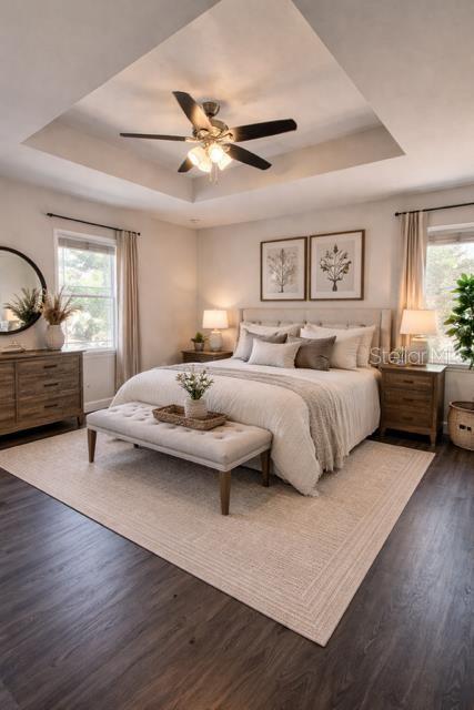A bedroom features a tray ceiling, a ceiling fan, a bed with a bench, and furniture — 9880 NW 110TH STREET, CHIEFLAND, FL