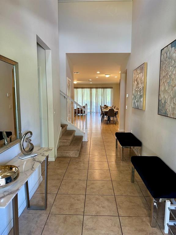 A tiled entryway leads to a staircase and a dining area with large glass doors — 1941 NICE COURT, KISSIMMEE, FL