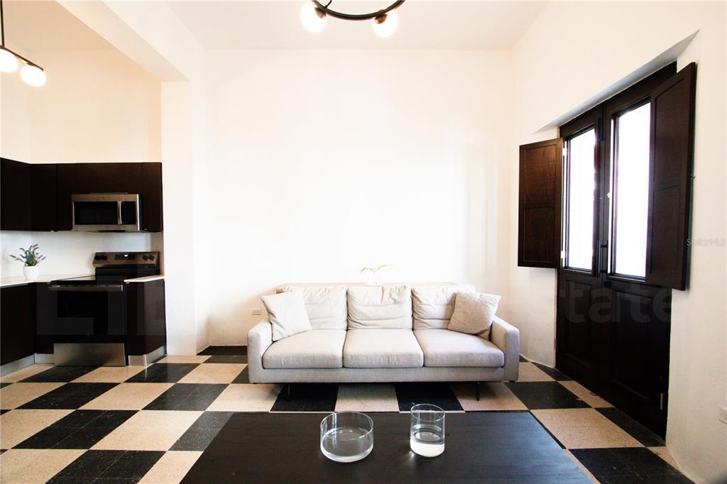 A living room features a light gray sofa, a black coffee table, and checkered flooring — 254-256 SAN FRANCISCO STREET UNIT 202, SAN JUAN, PR