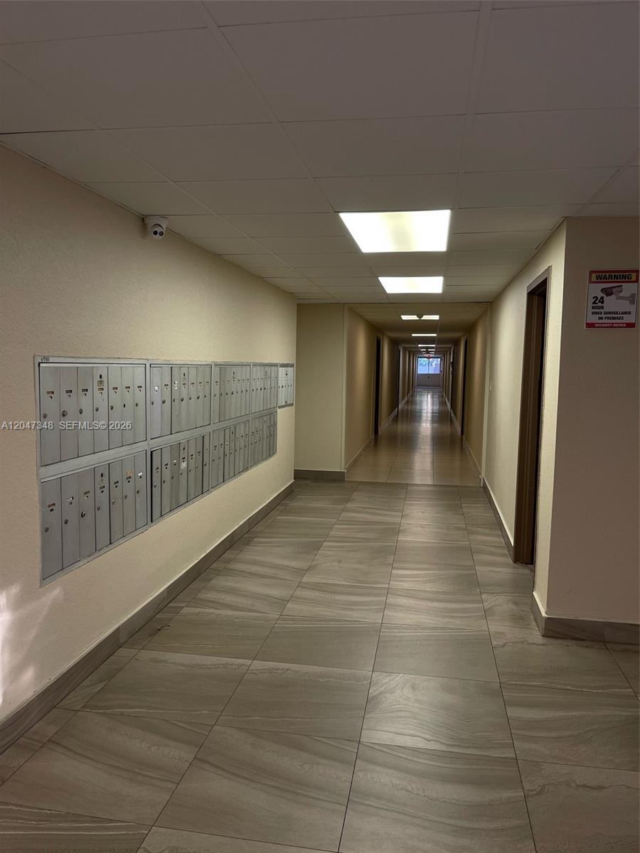 A hallway features a wall of metal mailboxes, tiled flooring, and recessed ceiling lighting — 6950 Miami Gardens Dr # 312A, Hialeah FL 33015, HIALEAH, FL