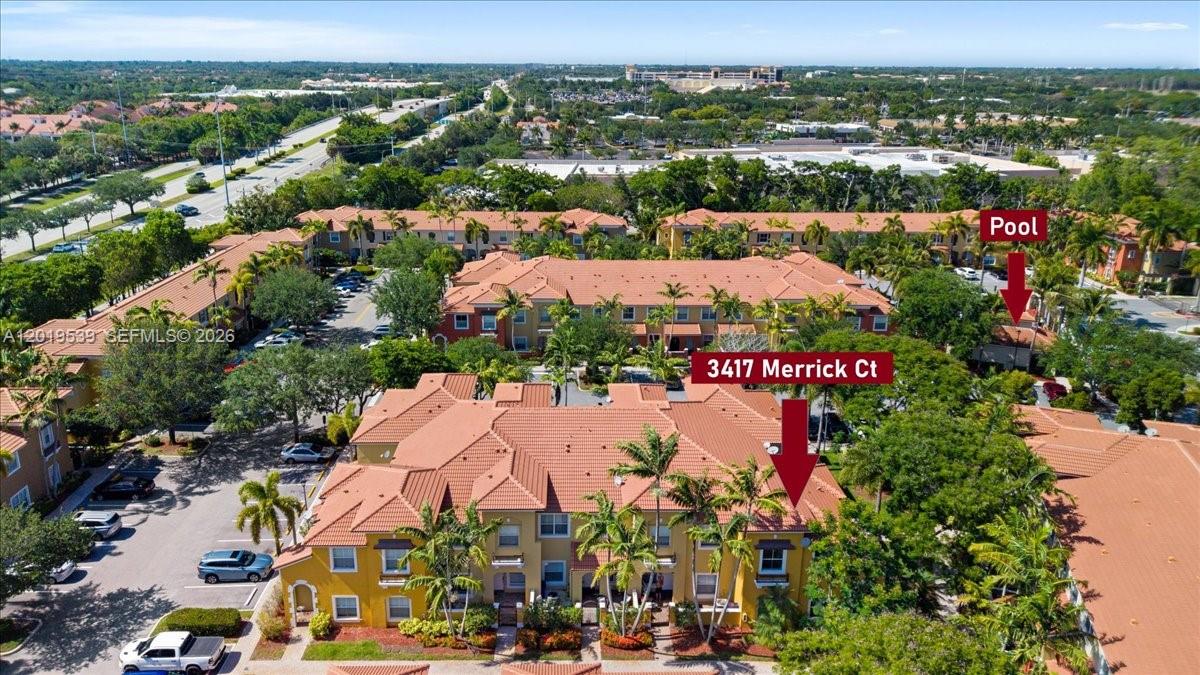 An aerial view shows a multi-story residential complex with tile roofs and a swimming pool — 3417 Merrick Ct # 1206, Margate FL 33063, MARGATE, FL