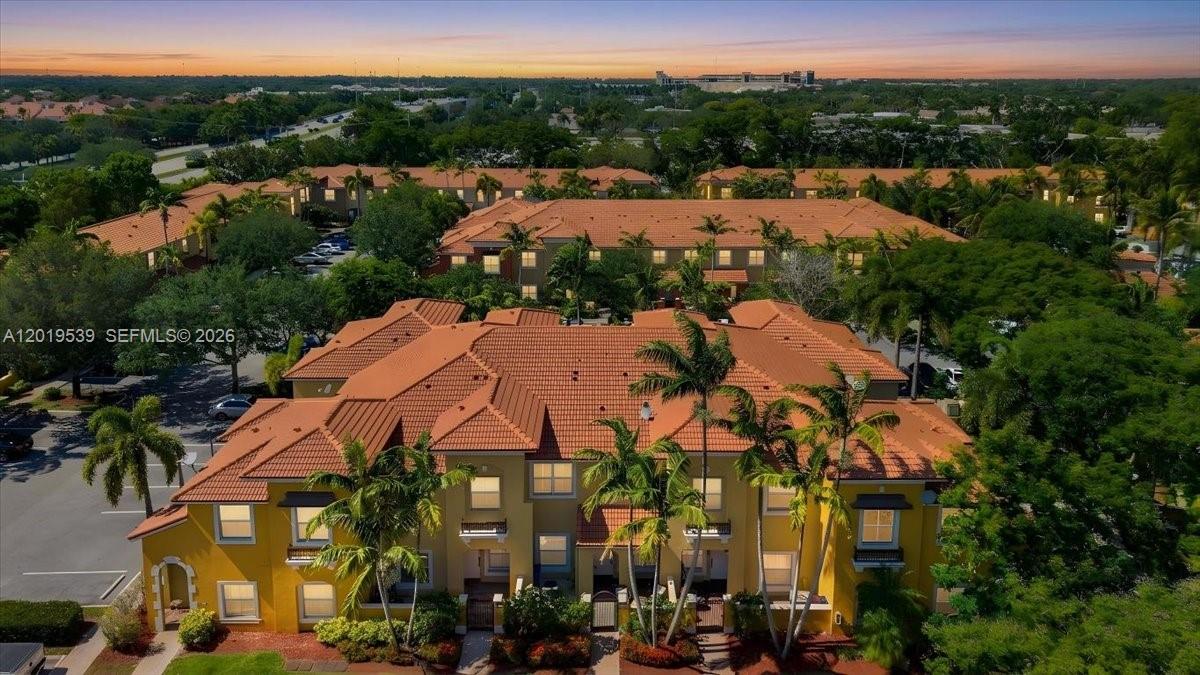 An aerial view shows a multi-story yellow apartment building with a red tile roof — 3417 Merrick Ct # 1206, Margate FL 33063, MARGATE, FL