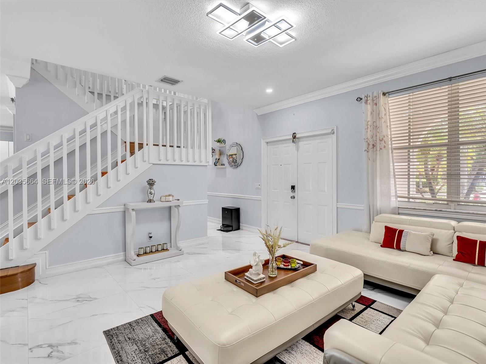 A living room features white tile floors, a staircase, and a white leather sectional sofa — 1581 Winterberry Ln, Weston FL 33327, WESTON, FL